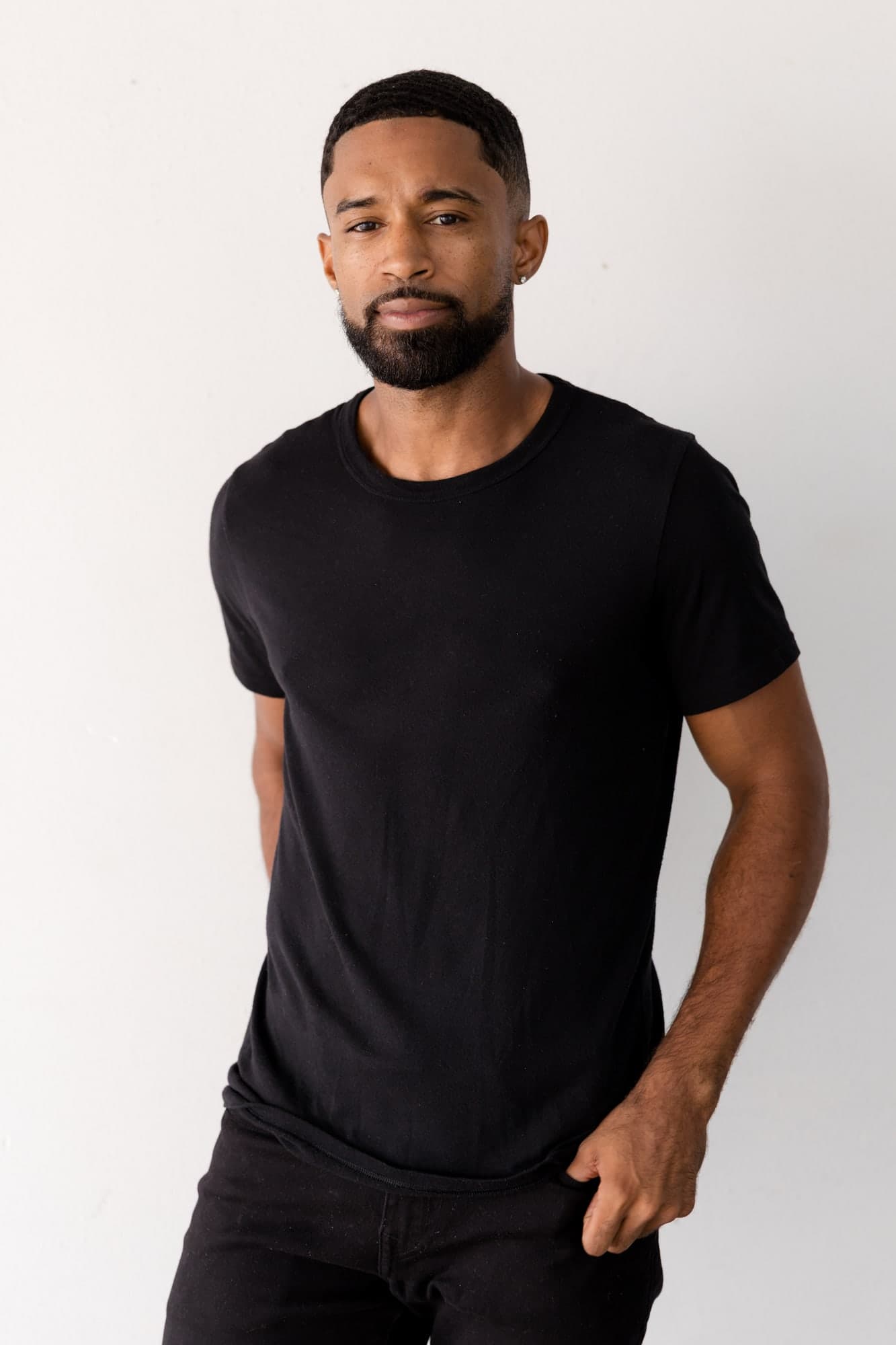 Three-quarter digital of Abyon Ausar in a black tee against a white wall