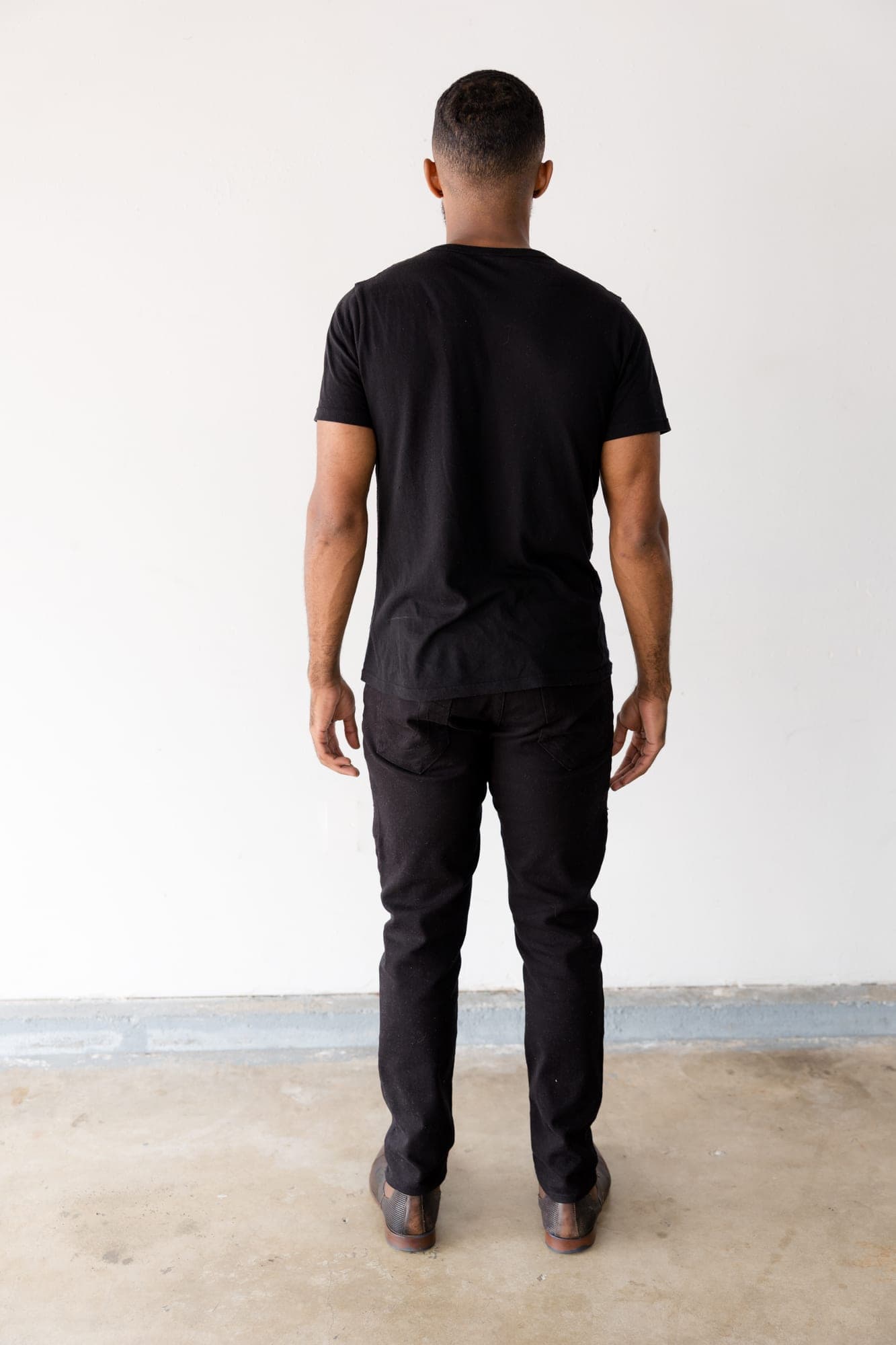 Full length digital of Abyon Ausar from behind against a white wall